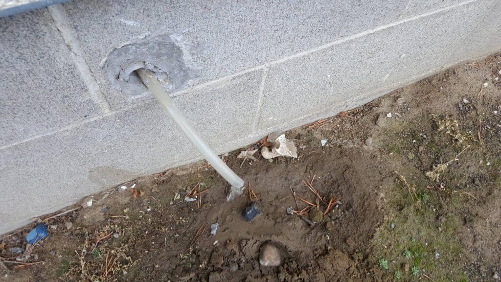 condensate drainage pipe from a whole in a wall.