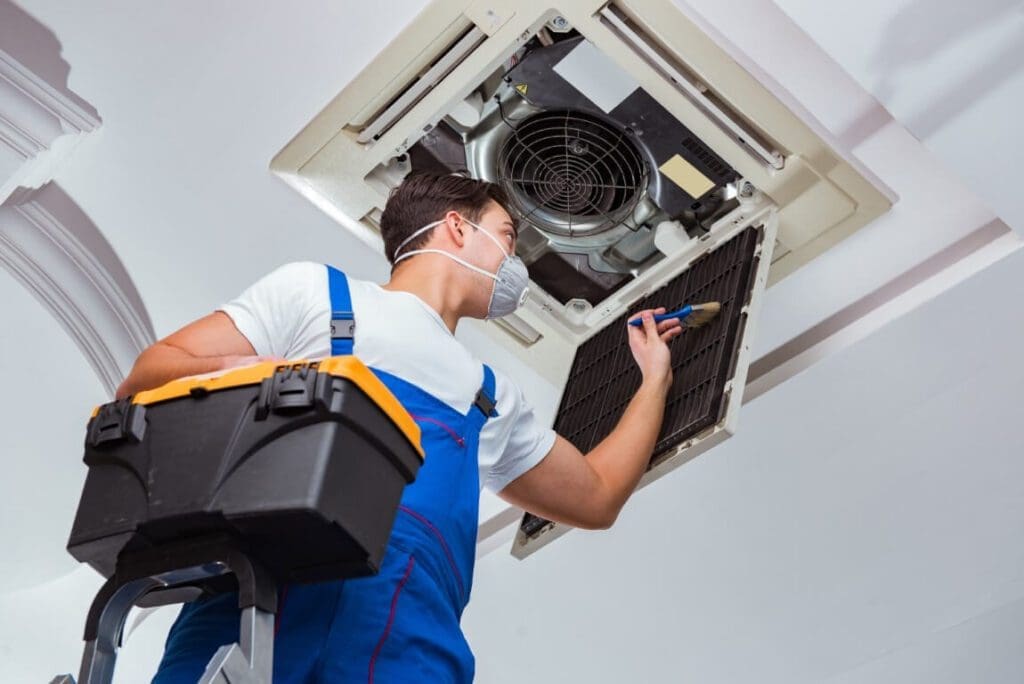a person is repairing heat and air conditioning system in a house.
