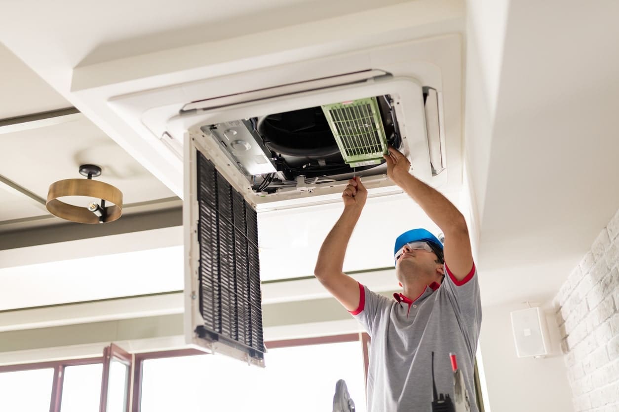 a technician repairing air vents of hvac system.