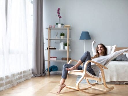 a woman sitting on a chair in happy mode in a fresh indoor environment.