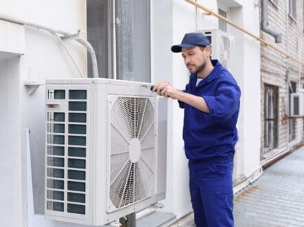 a guy checking outer of hvac system