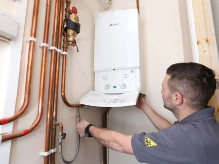 a technician installing boiler system at home.