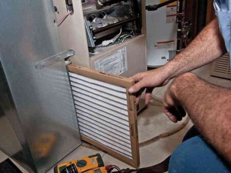 a person is replacing furnace filter.