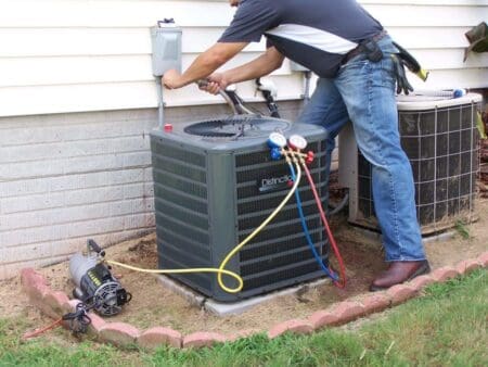 a person is installing outdoor unit of hvac system